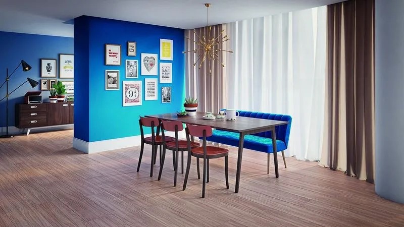 sala de jantar com piso laminado de estilo rústico, parede azul com quadros, cortinas longas e mesa com cadeiras de madeira e banqueta azul