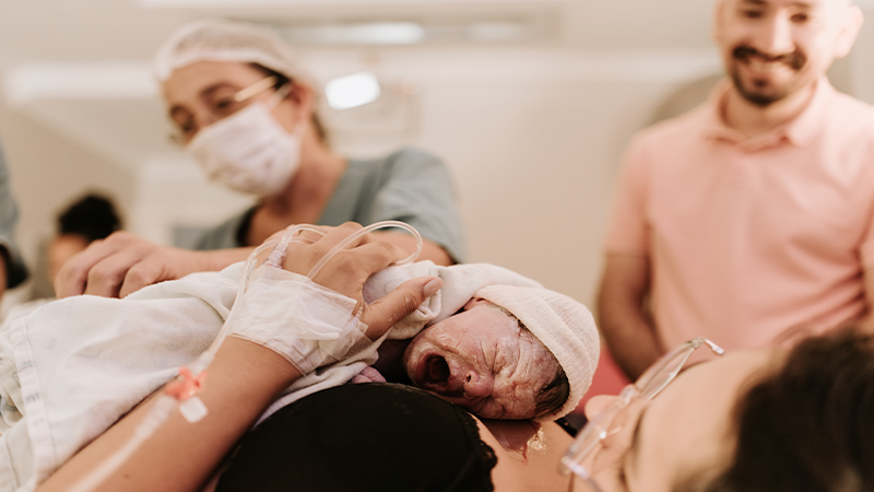 Recém-nascido sendo acolhido pela mãe e equipe médica