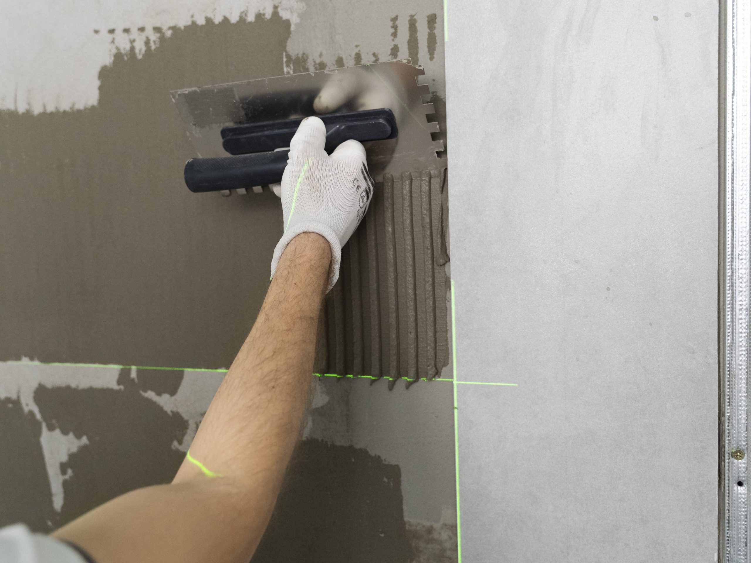 Aplicação de massa em parede com desempenadeira