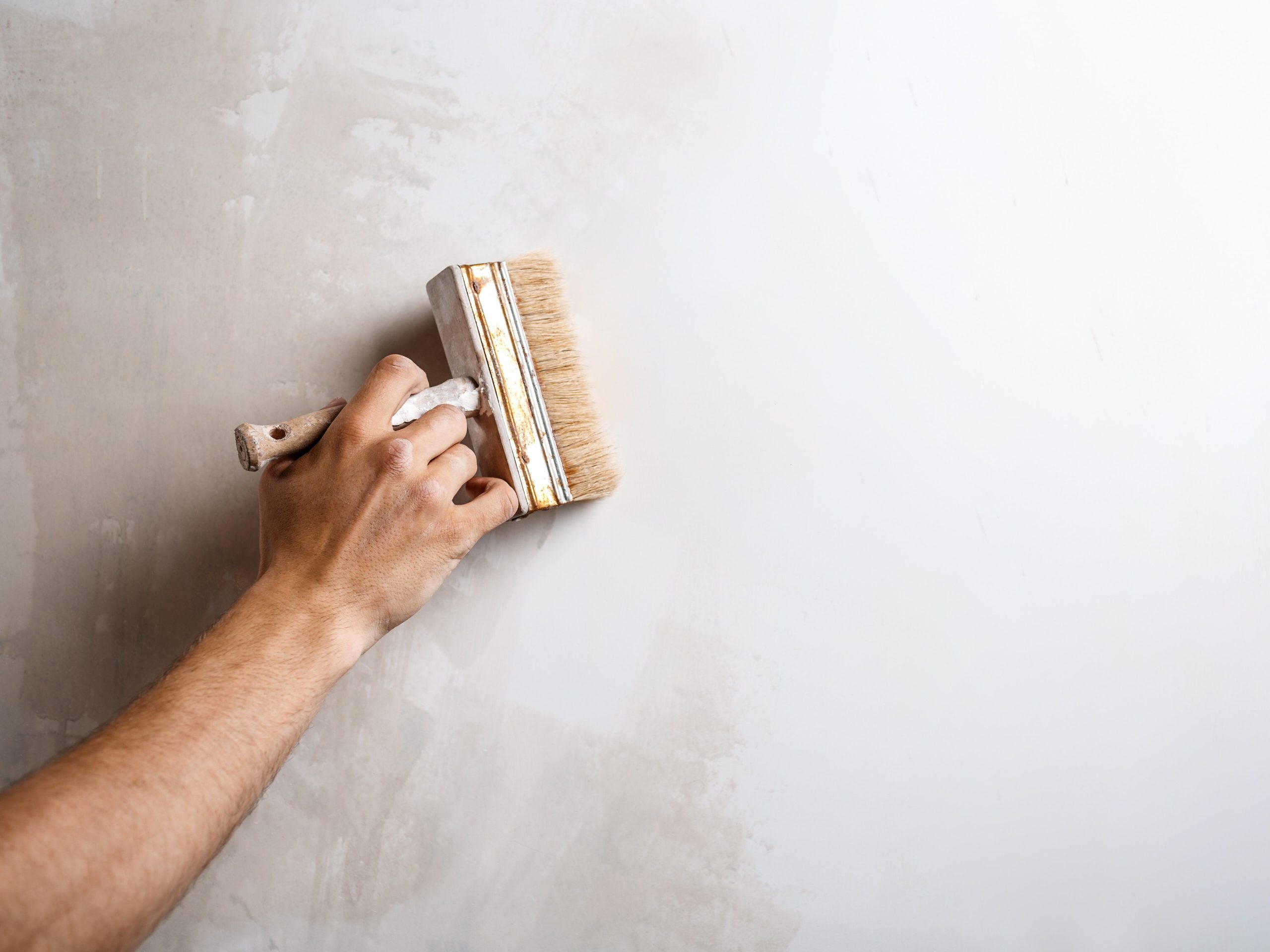 feche-acima-da-parede-da-pintura-da-mao-com-escova.jpg