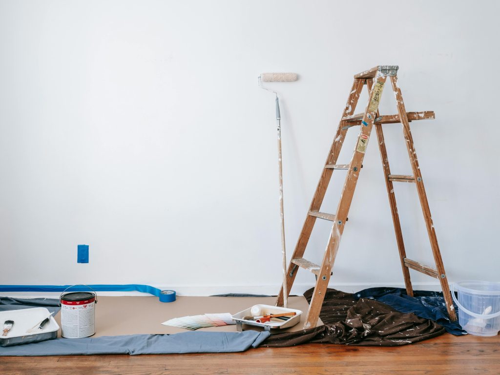 Área de pintura com escada e materiais.