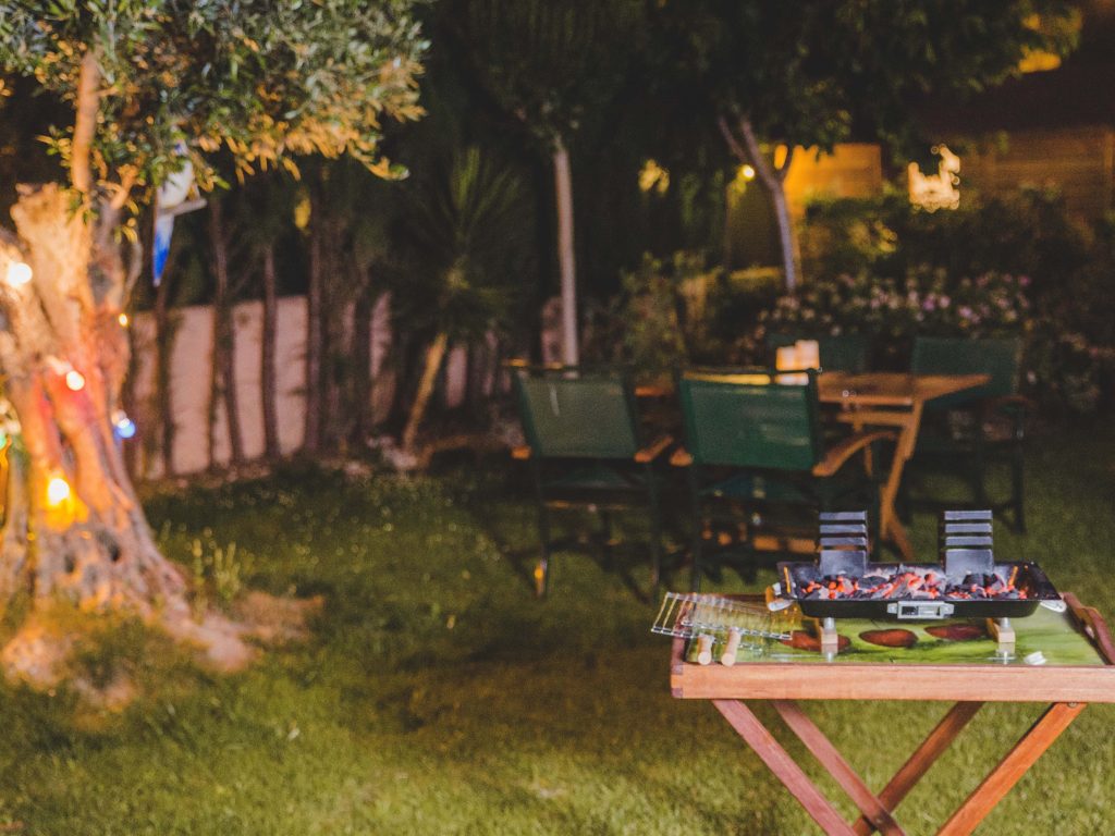 Churrasqueira em um jardim iluminado à noite