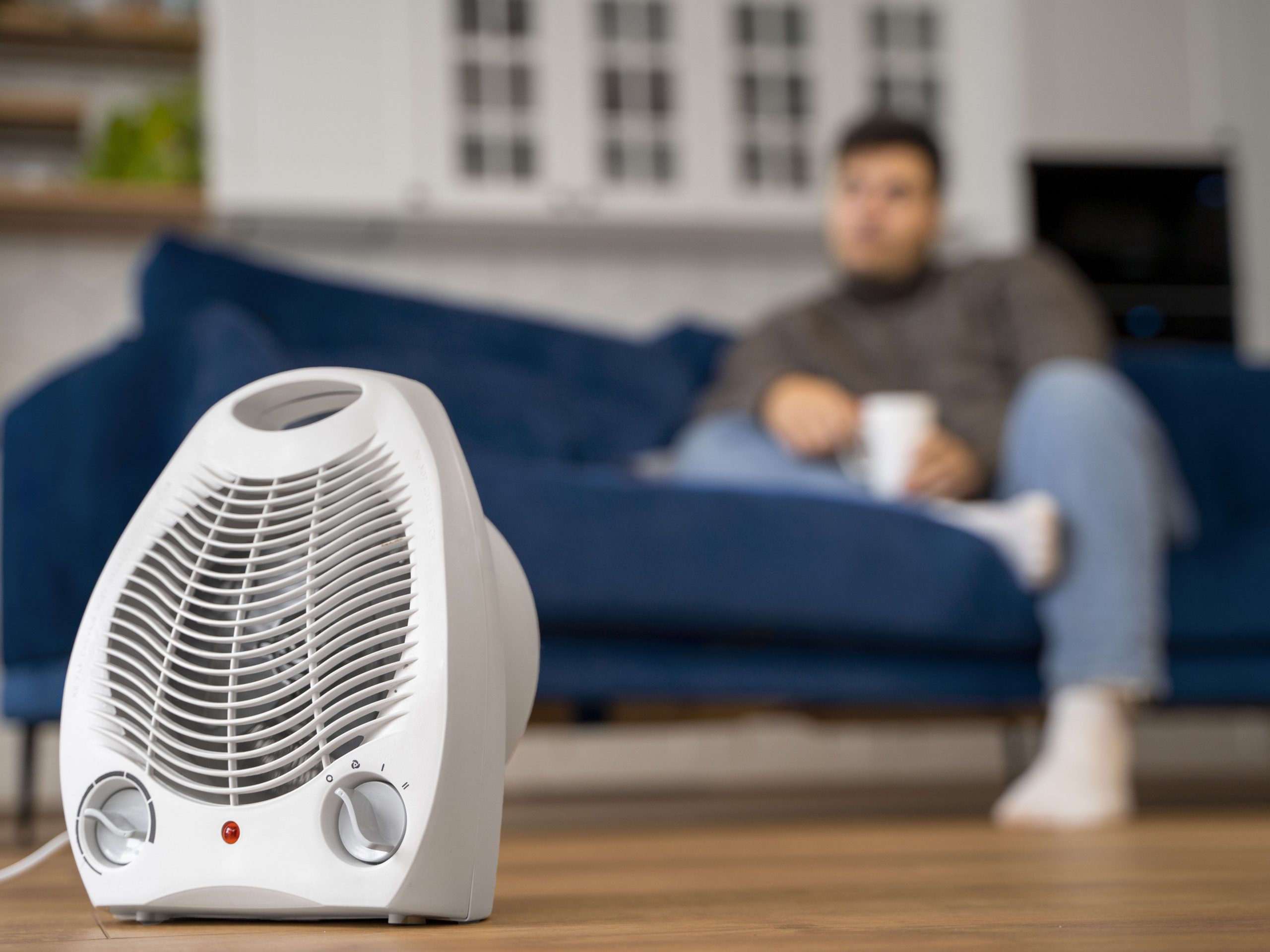 Aquecedor em foco com pessoa relaxando ao fundo