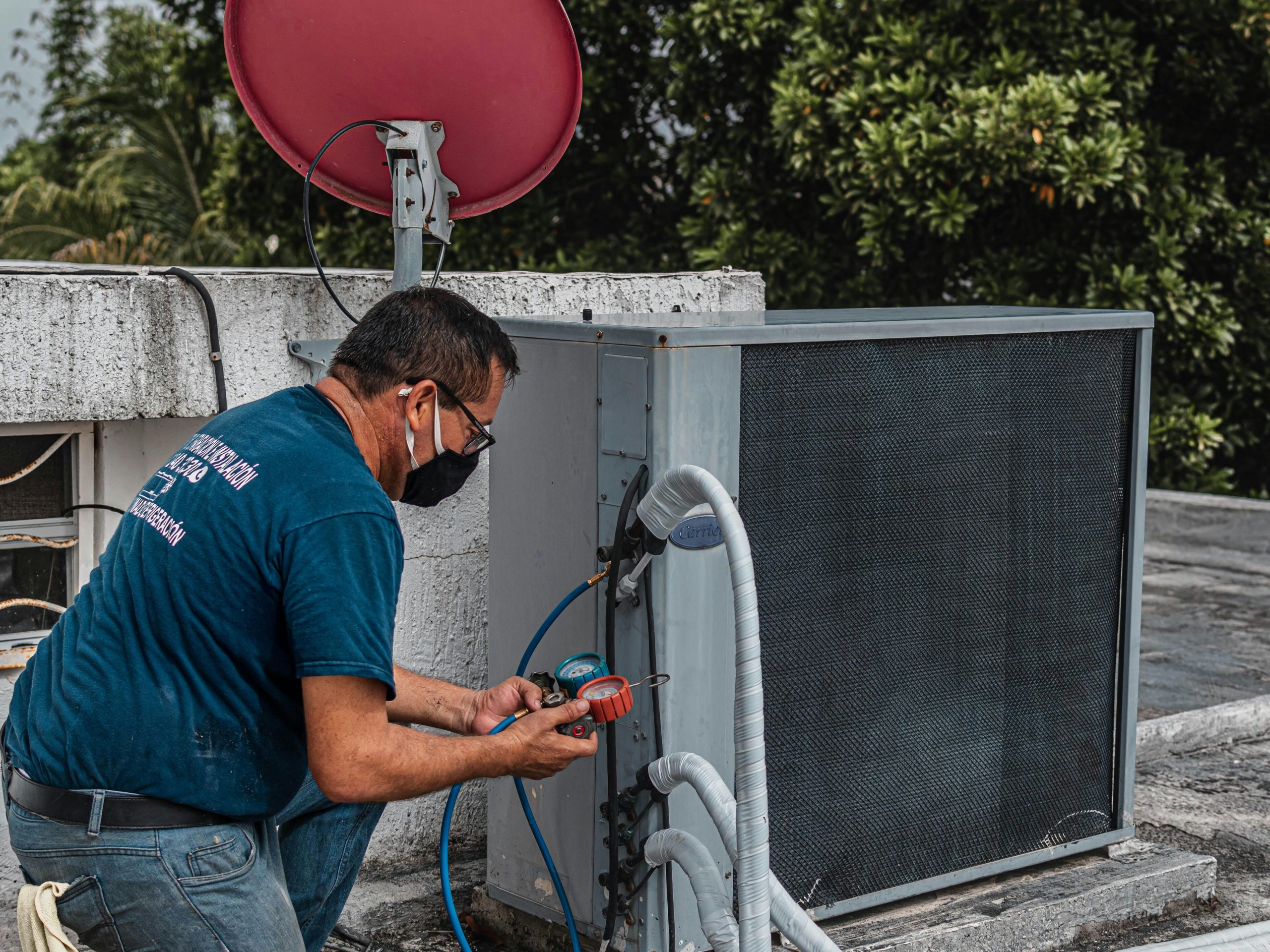 técnico ajustando bomba de ar condicionado no telhado