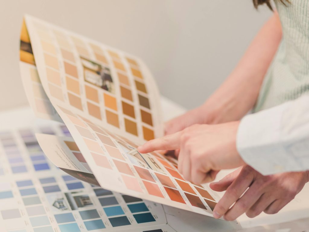 Mãos escolhendo amostras de tinta colorida