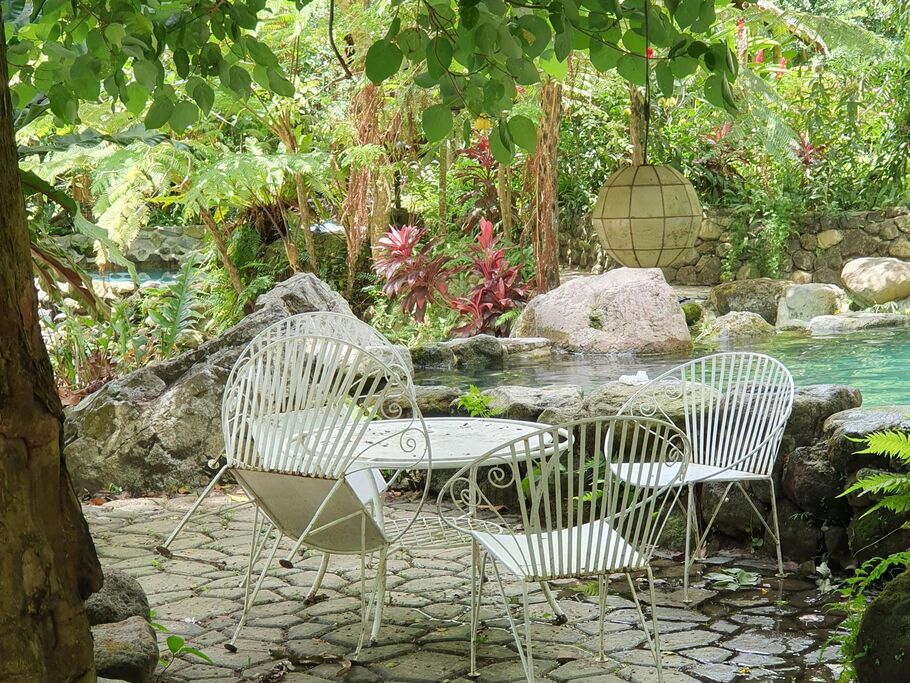 Espaço ao ar livre com cadeiras brancas e piscina