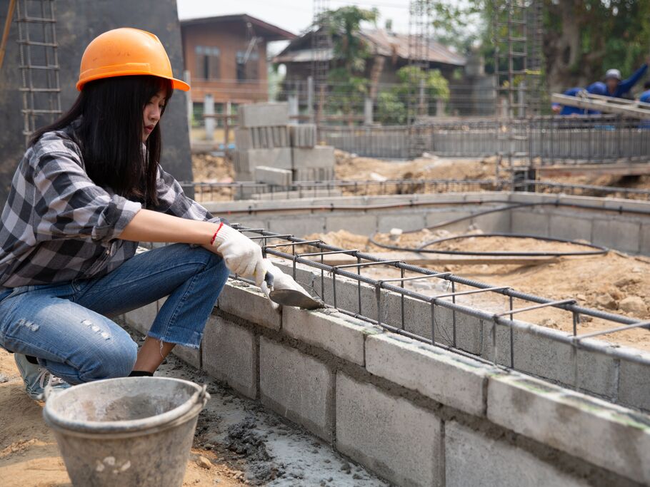 Mulher trabalhando em construção civil com tijolos