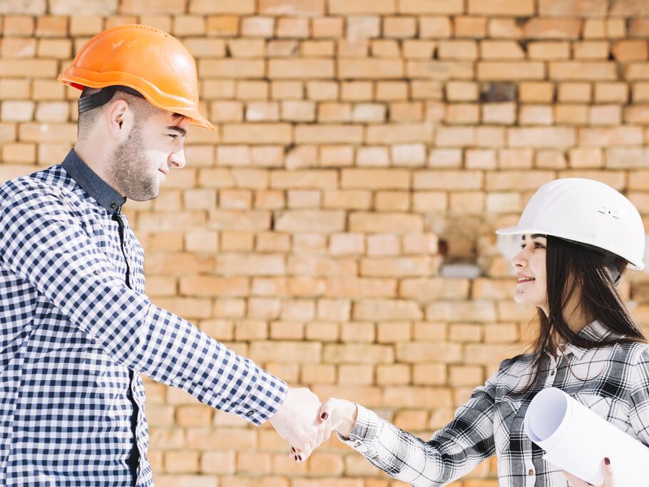 Profissionais da construção civil se cumprimentando.