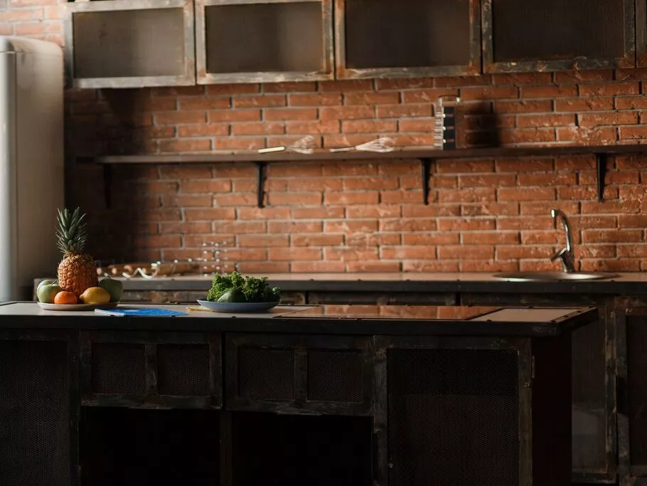 dark-loft-kitchen-with-red-brick-wall-kitchen-table-cutlery-spoons-forks-breakfast-fruit.jpg