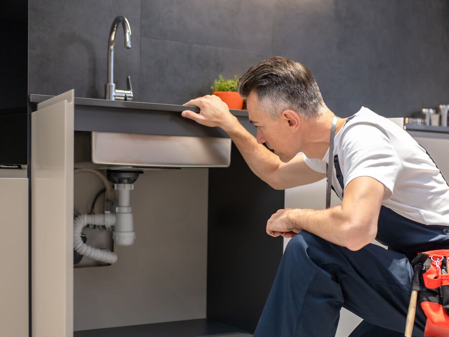 Profissional consertando pia na cozinha moderna