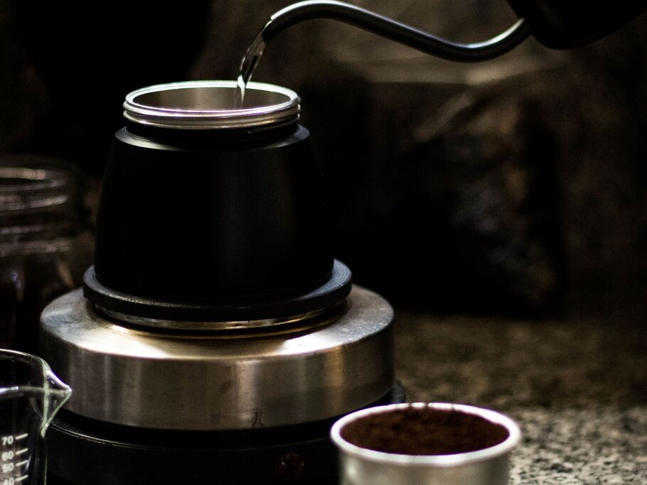 Preparo de café com água aquecida e jarra preta